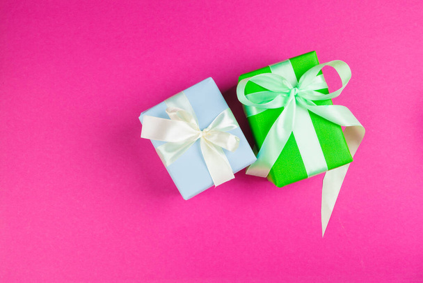 Top view of a decorated present with a bow on pink background - 写真・画像