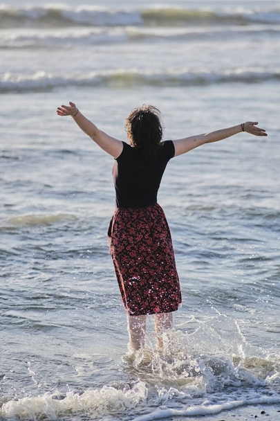 joven chica consiguiendo sus pies mojado en la playa - Foto, Imagen