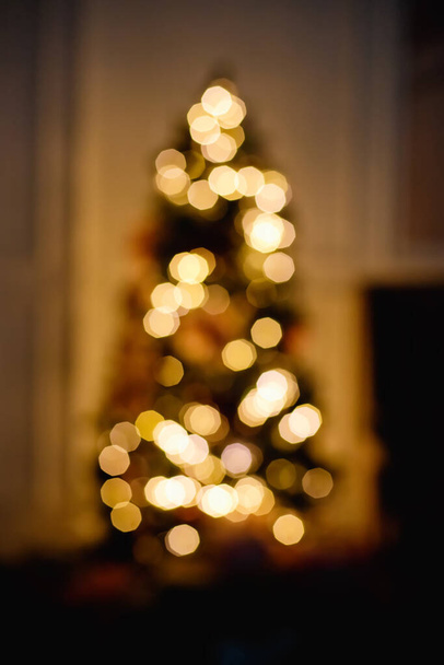 Bulanık ışıklı noel ağacı silueti. Dikey çerçeve - Fotoğraf, Görsel