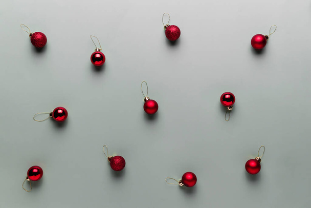 Шаблон на сером фоне с маленькими красными рождественскими шарами, шаровые елочные игрушки - Фото, изображение