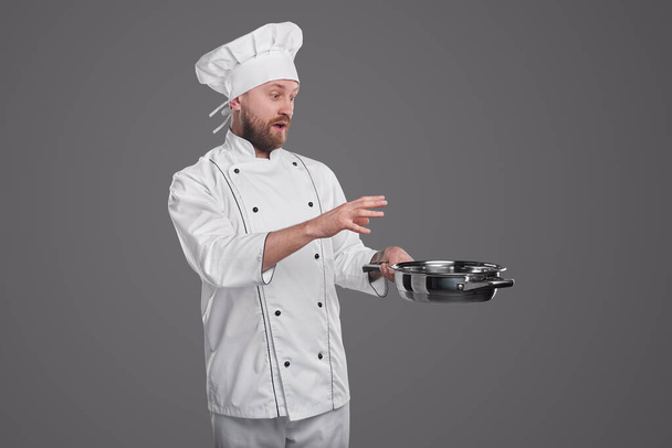 Surprised cook with pan on gray background - Foto, Imagem