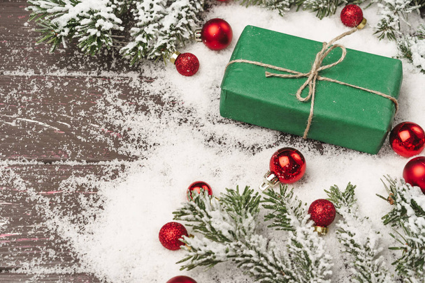 Christmas gift on wooden table powdered with snow - Photo, image