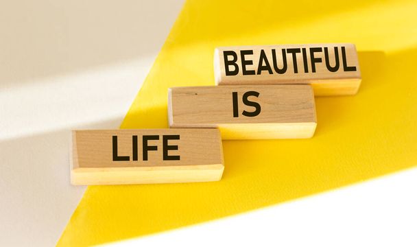 Citazioni motivazionali La vita è grande, su blocchi di legno e sfondo bianco e giallo. - Foto, immagini