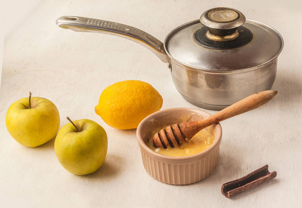 Cooking apple, lemon and cinnamon sticks vitamin cocktail. - Photo, Image