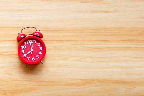 Red alarm clock on wooden table background. - Photo, Image