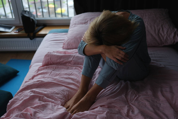 Samotna smutna kobieta siedzi na łóżku zbliżenie - Zdjęcie, obraz