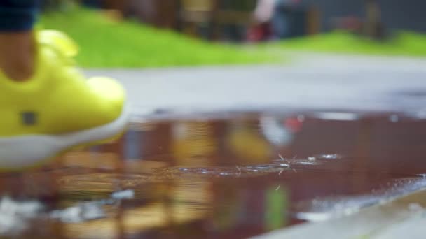 Sportlerinnen joggen im Freien, treten in Pfützen. Ein einzelner Läufer läuft im Regen und macht Spritzer. Zeitlupe - Filmmaterial, Video