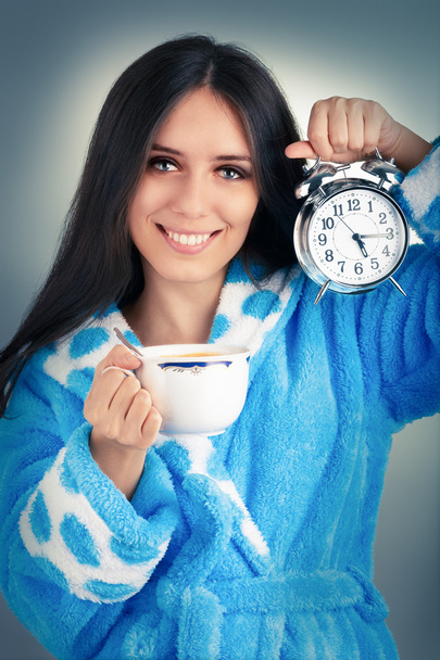 Young Woman in Bathrobe Holding an Alarm Clock and a Cup of Coffee - Foto, Imagen