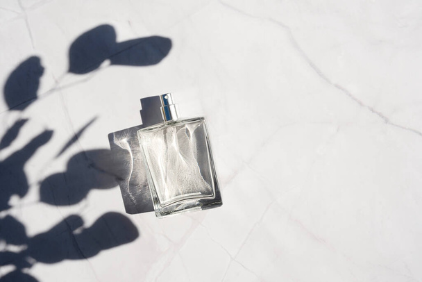 Transparante fles parfum met spray op wit marmeren oppervlak. - Foto, afbeelding