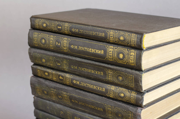 Undici volumi del famoso scrittore, pensatore, filosofo e saggista russo Fyodor Dostoevsky. Una pila di vecchi libri con copertina rigida su sfondo grigio. Ucraina, Mykolaiv - 10 11 2021 - Foto, immagini