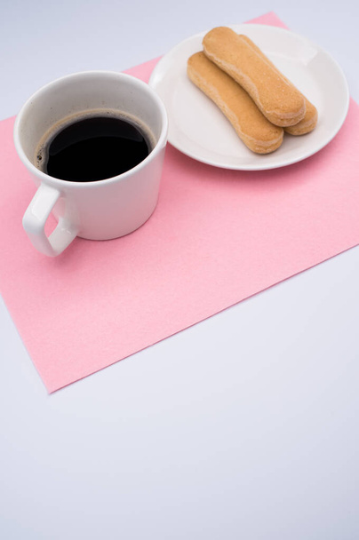 black coffee in a mug and plate with savoiardi biscuits on a wooden background with copy space - Photo, Image