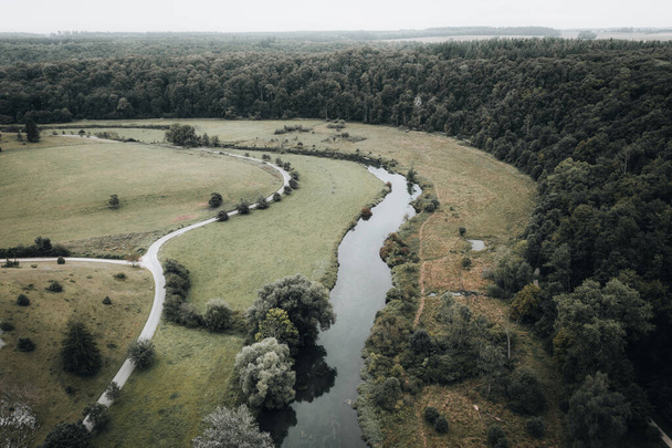 An aerial landscape of a curvy highway through the highland woods - Foto, Imagen