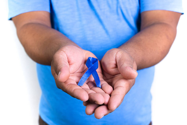 A man holding thyroid cancer awareness blue ribbon in his hands - Fotografie, Obrázek
