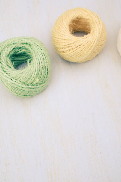 multicolor decoration yarns on a bright wooden background with copy space - Photo, image