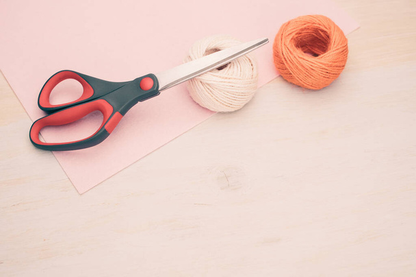 multicolor decoration yarns with scissors on a bright wooden background with copy space - Valokuva, kuva
