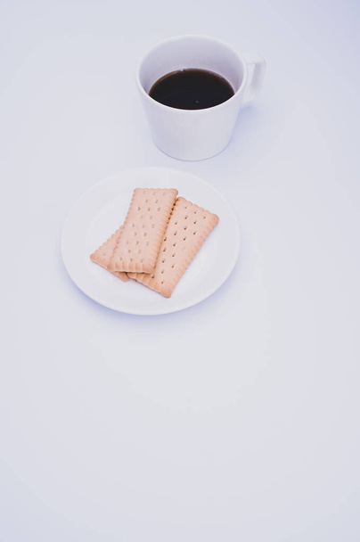 black coffee in a mug and plate with biscuits on a white background with copy space - Foto, Imagem