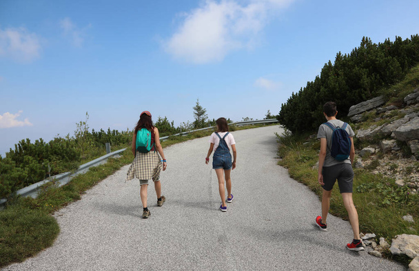 madre con hija e hijo durante un paseo por la carretera en las montañas en verano - Foto, Imagen