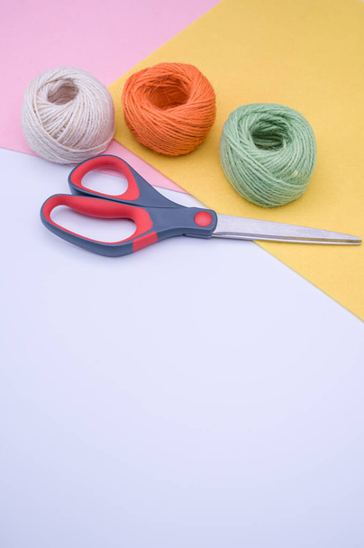 multicolor decoration yarns with scissors on a bright wooden background with copy space - Foto, immagini