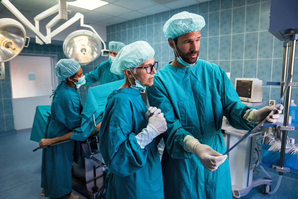 Groep van diverse chirurgen aan het werk in operatiekamer in ziekenhuis - Foto, afbeelding