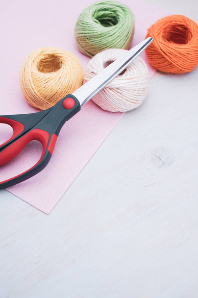 multicolor decoration yarns with scissors on a bright wooden background with copy space - Foto, Imagen