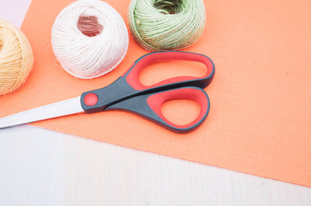 multicolor decoration yarns with scissors on a bright wooden background with copy space - Foto, afbeelding