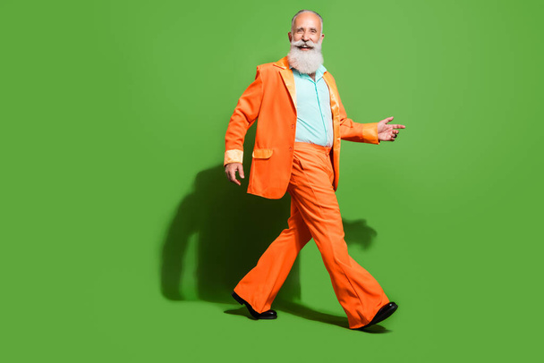 Full length body size view of attractive glad classy cheerful grey-haired man walking isolated over bright green color background - Fotoğraf, Görsel