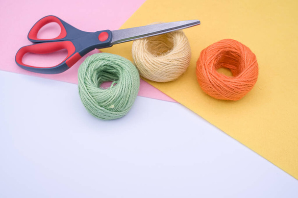 multicolor decoration yarns with scissors on a bright wooden background with copy space - Foto, Imagem