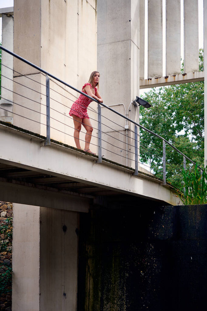 A vertical shot of a Spanish female standing on the balcony - Zdjęcie, obraz
