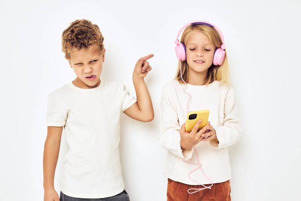 Due bambini in età prescolare ragazzo e ragazza sorridente con il telefono in mano stile di vita infanzia - Foto, immagini