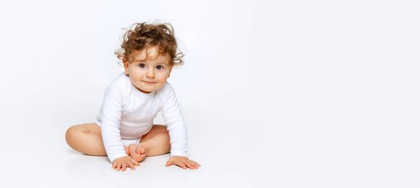 Curiosidad, niña juguetona. Retrato de un niño pequeño y lindo, bebé en pañal aislado sobre fondo blanco del estudio. Concepto de infancia, maternidad, vida, nacimiento. Copiar espacio para anuncio - Foto, Imagen