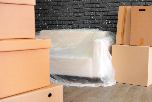 Moving in or moving out concept. Stack of boxes and packed furniture - Φωτογραφία, εικόνα