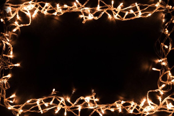 Christmas lights border. Christmas background with lights and free text space. Christmas lights on black background. New Year. - Fotó, kép