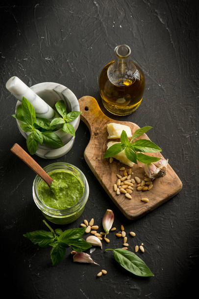 traditional italian pesto with ingredients over black background - 写真・画像