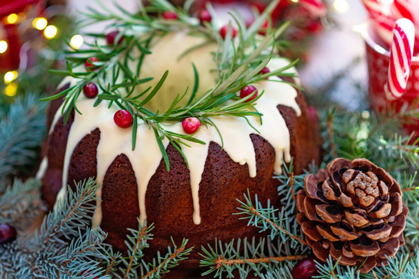 Χριστουγεννιάτικο καραμελένιο κέικ, διακοσμημένο με λευκή σοκολάτα, cranberry, δενδρολίβανο και διακόσμηση Πρωτοχρονιάς. Εορταστική ψημένα αγαθά. Μαλακή επιλεκτική εστίαση. Οριζόντια - Φωτογραφία, εικόνα
