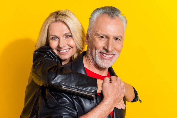 Portrait of attractive cheery pensioner grey-haired friendly lovers having fun embracing isolated over bright yellow color background - Fotó, kép