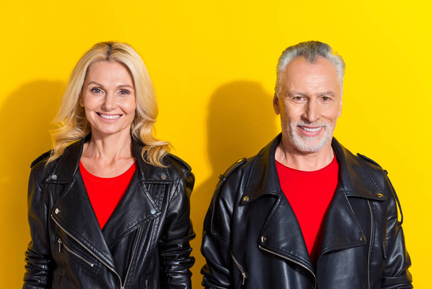 Portrait of two attractive cheerful fashionable grey-haired spouses isolated over bright yellow color background - Foto, Imagen