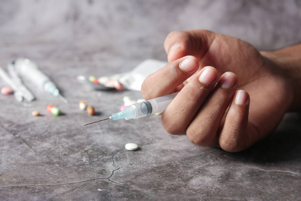 conceito de dependência de drogas com a posse de uma seringa e pacote de heroína na mesa  - Foto, Imagem