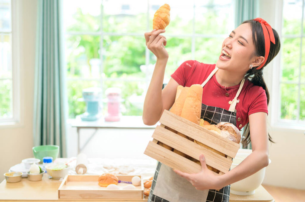 A young beautiful Asian woman is baking in her kitchen  , bakery and coffee shop business  - 写真・画像