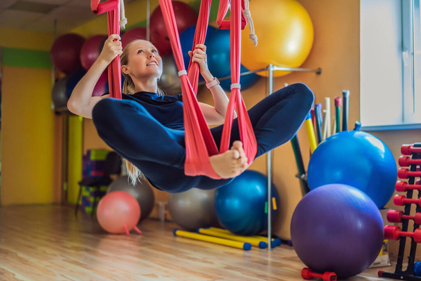 Young beautiful woman practicing aerial yoga in gym. Lifestyle - Fotoğraf, Görsel
