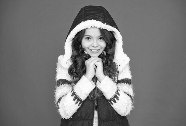 happy teen girl with long curly hair wear puffer waistcoat and sweater with christmas patterns, winter fashion - Φωτογραφία, εικόνα