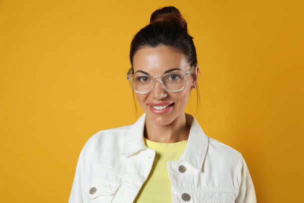 Beautiful woman in eyeglasses on yellow background - Foto, Imagem