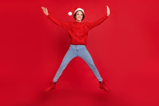 Full length photo of young girl happy positive smile jump up holiday winter isolated over red color background - Foto, Imagem