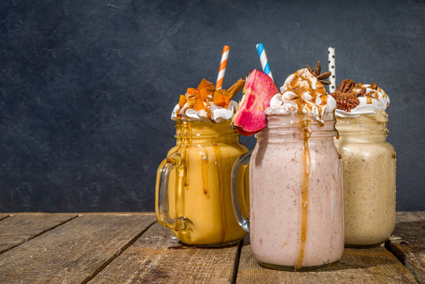 Apple, pumpkin and pecan pie smoothie drinks. Traditional autumn baking cake flavor cocktails set, on dark wooden background copy space - Foto, immagini