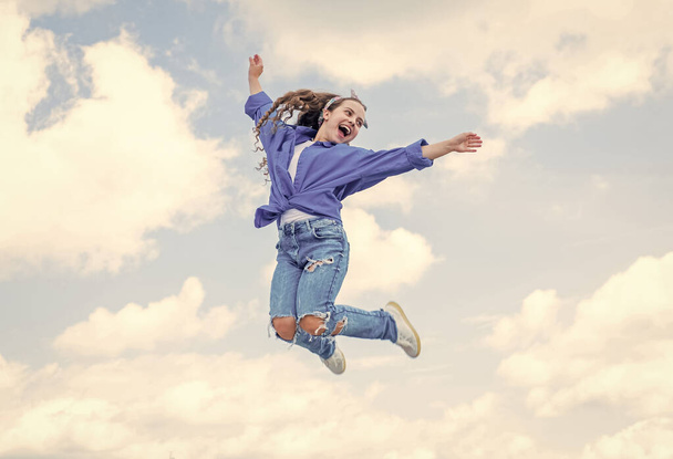 Fashion is her life. teen girl jumping high in the sky. having a party fun. Happy kid wear shirt. Lifestyle and People Concept. kid spring and fall fashion. full of energy. childhood happiness - Фото, зображення