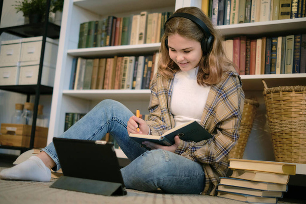 Teenage girl doing homework at a desk in her bedroom. teen girl school student write notes watch video online webinar learn on laptop. distance elearning course video conference pc call. - Φωτογραφία, εικόνα