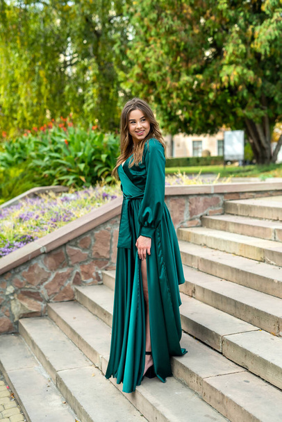 full length young elegant woman in beautiful green gress standing in stone   stair, city lifestyle  - Foto, Bild