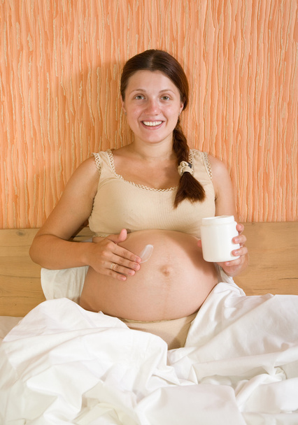 Pregnant woman applying cream - Foto, imagen