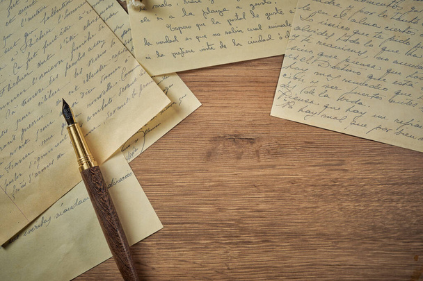 Vintage íróeszközök egy fa asztalra, régi óra, papírok, levelek, borítékok és ollók - Fotó, kép