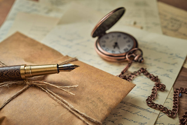 Ročník psací potřeby na dřevěný stůl, staré hodinky, papíry, dopisy, obálky a nůžky - Fotografie, Obrázek