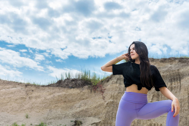 Çölün kumları arasında yürüyen genç bir kadın ya da mavi gökyüzü ile taş ocağı, doğada mükemmel bir yaşam tarzı. - Fotoğraf, Görsel